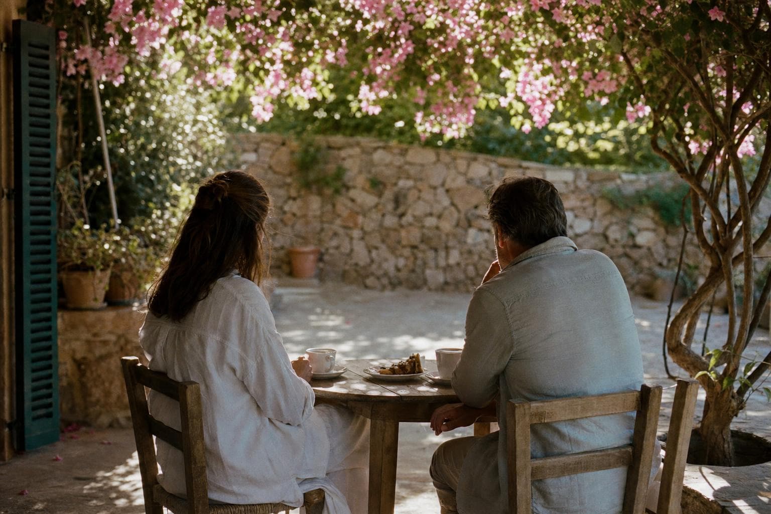 Two people in conversation over coffee on a finca terrace on Mallorca